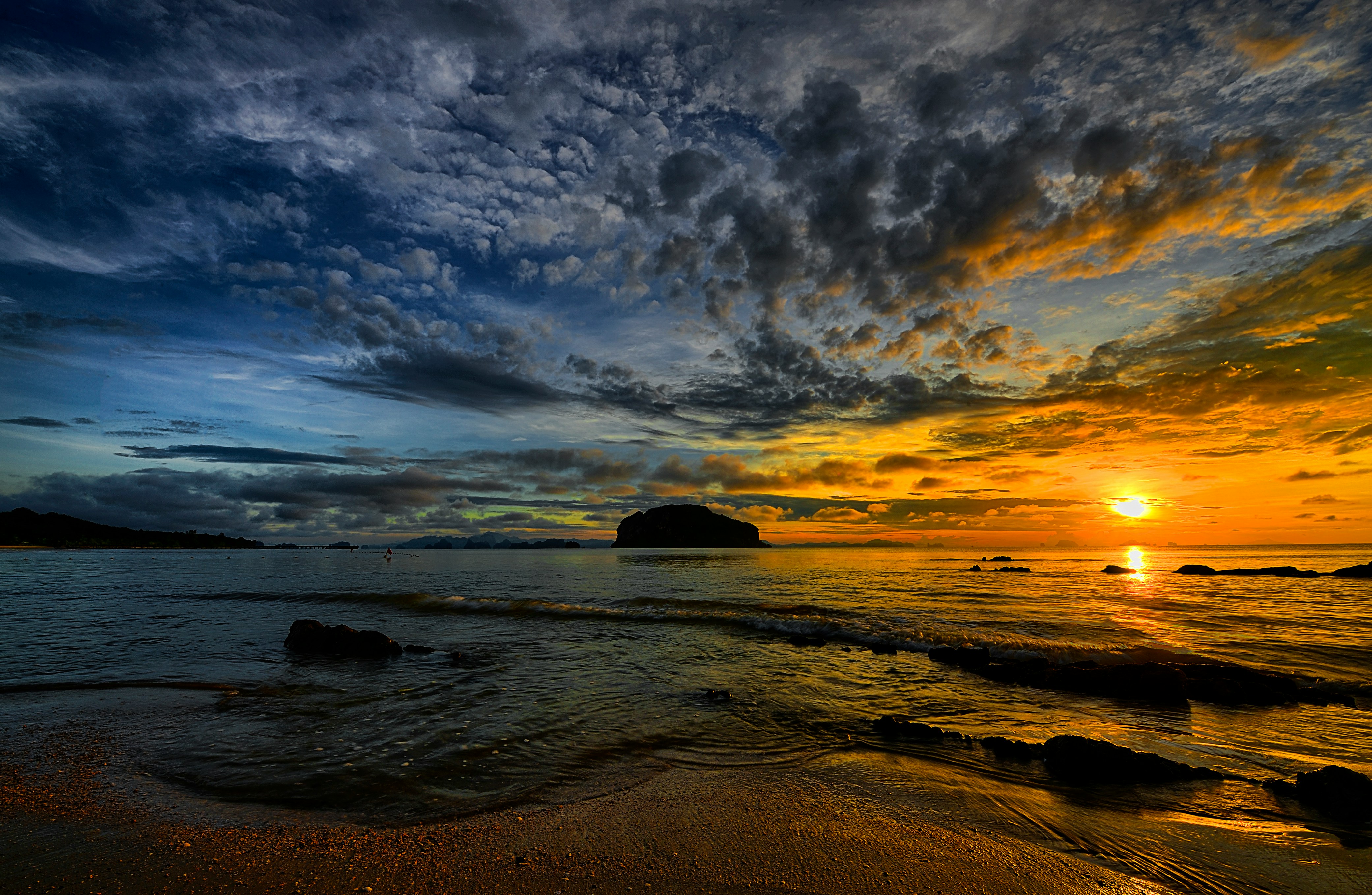 Low sun over a rocky island in the sea